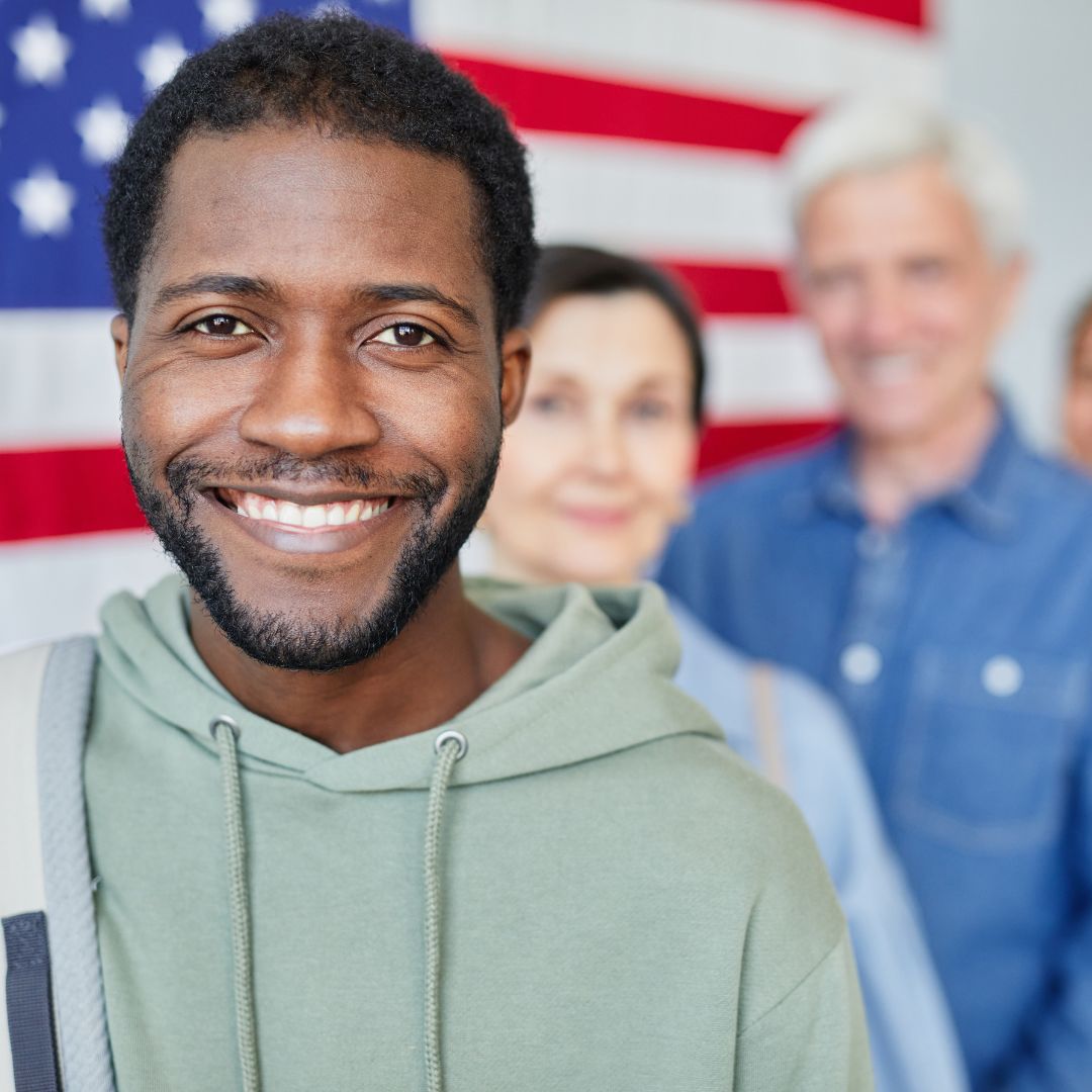 man with american flag behind him